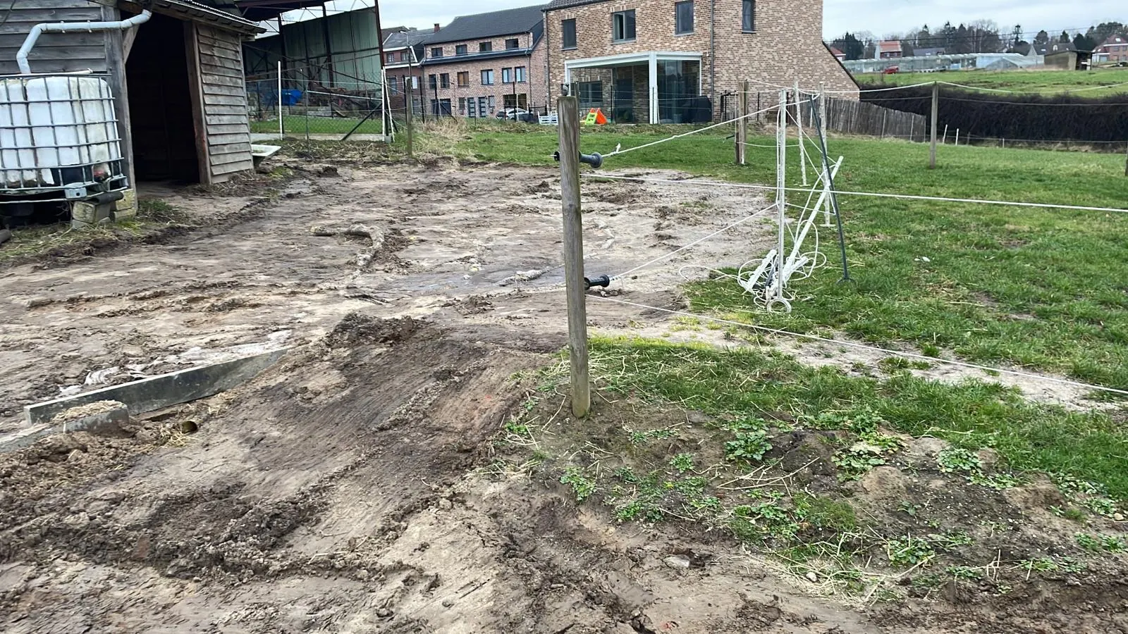 Voor: modderige, kapotgereden toegangsweg bij paardenstallen