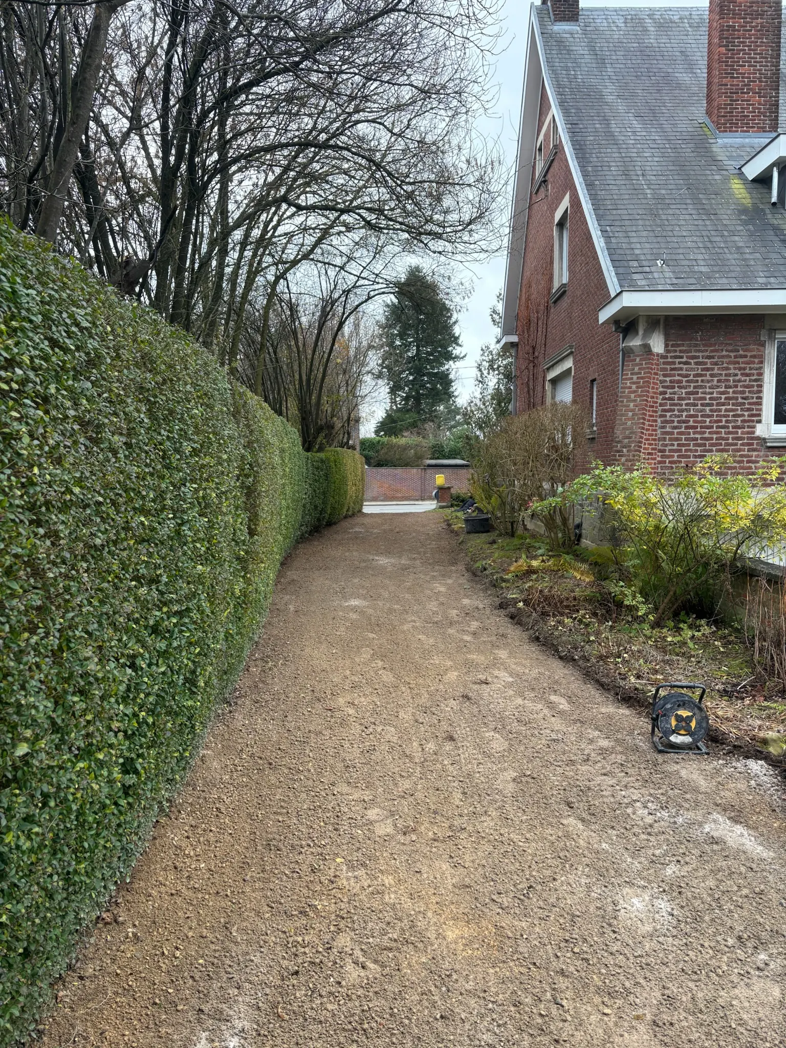 Longue allée en empierrement compacté le long d’une haie